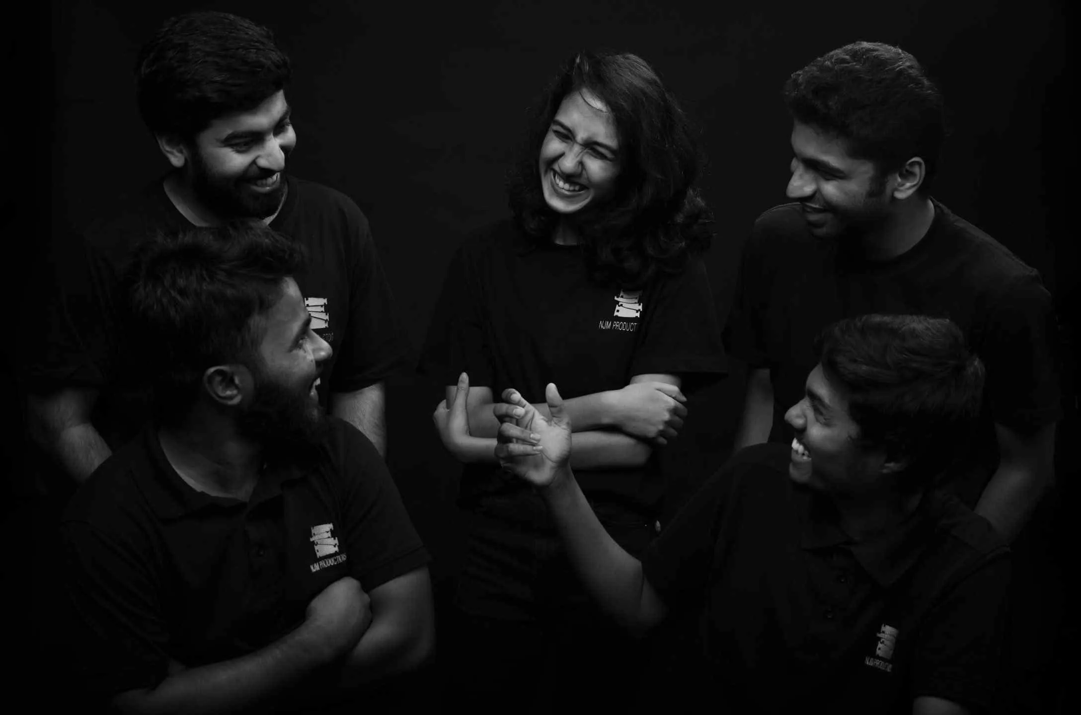 Five NJM collaborators smiling and talking together
